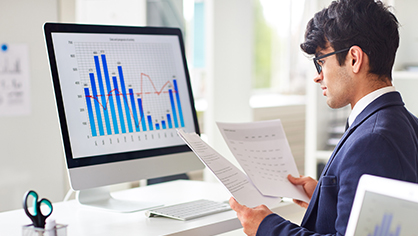 Financial analyst monitoring transactions and reviewing reports for AML compliance.